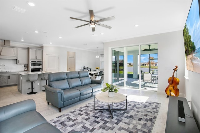 living room with light hardwood / wood-style floors, crown molding, and ceiling fan