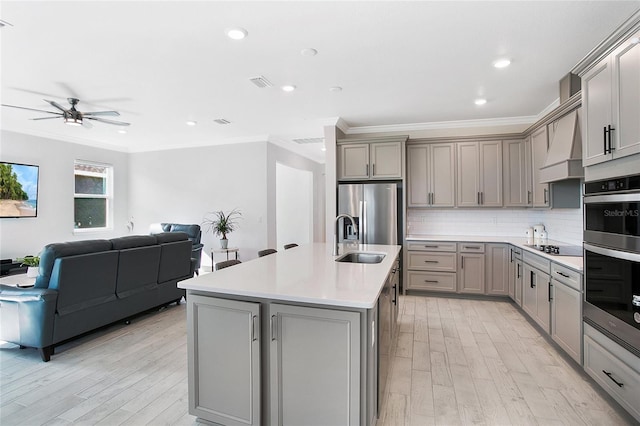 kitchen featuring custom range hood, stainless steel appliances, sink, and gray cabinets