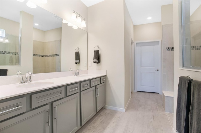 bathroom featuring vanity, hardwood / wood-style flooring, and tiled shower