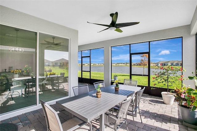 sunroom featuring a water view and ceiling fan