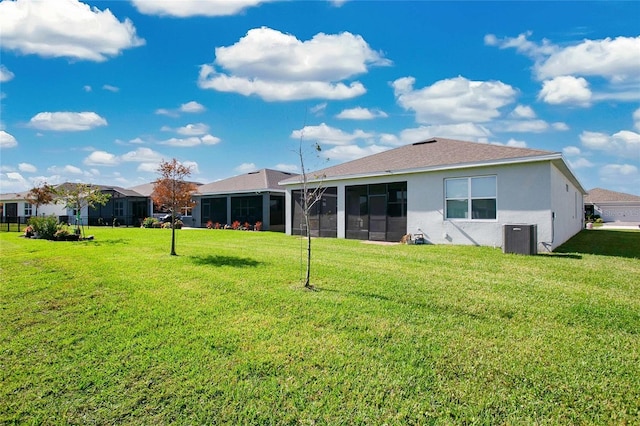 rear view of property featuring central air condition unit, a yard, and a sunroom