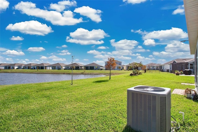 view of yard featuring central air condition unit and a water view