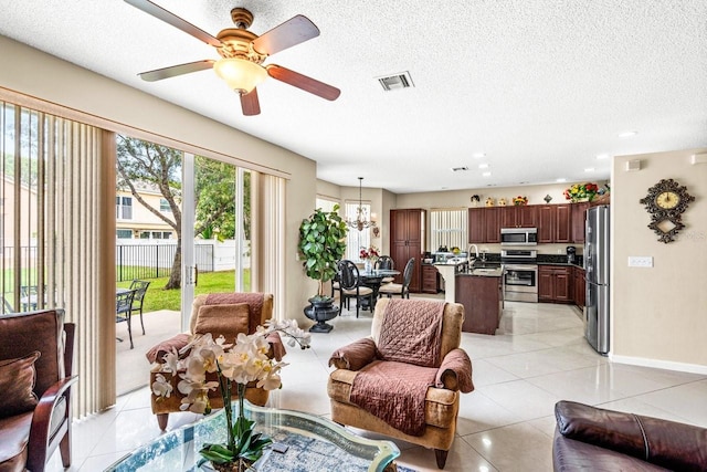 tiled living room with a textured ceiling, sink, and ceiling fan