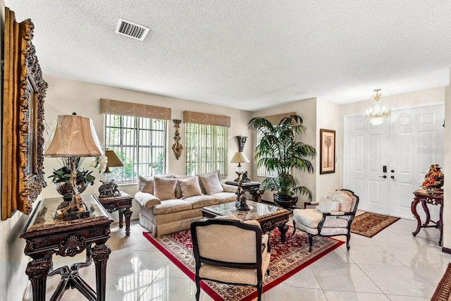 living room featuring light tile patterned flooring, a textured ceiling, and a chandelier