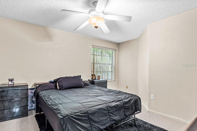 tiled bedroom featuring a textured ceiling and ceiling fan