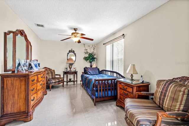 tiled bedroom featuring ceiling fan and a textured ceiling