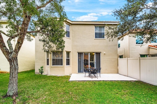 rear view of property featuring a patio and a lawn