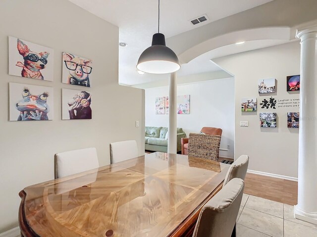 dining room with ornate columns and light hardwood / wood-style floors