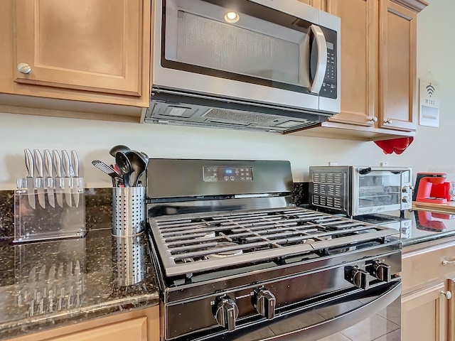 kitchen with appliances with stainless steel finishes, light brown cabinets, and tile patterned flooring