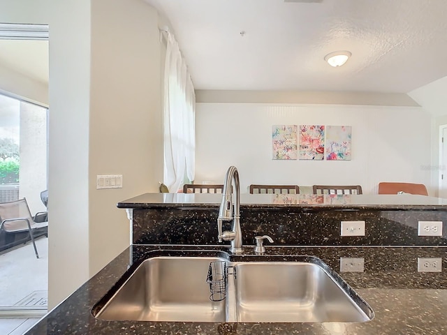 kitchen with sink and dark stone counters