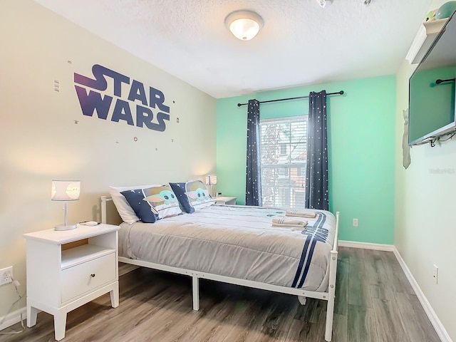 bedroom with hardwood / wood-style floors and a textured ceiling