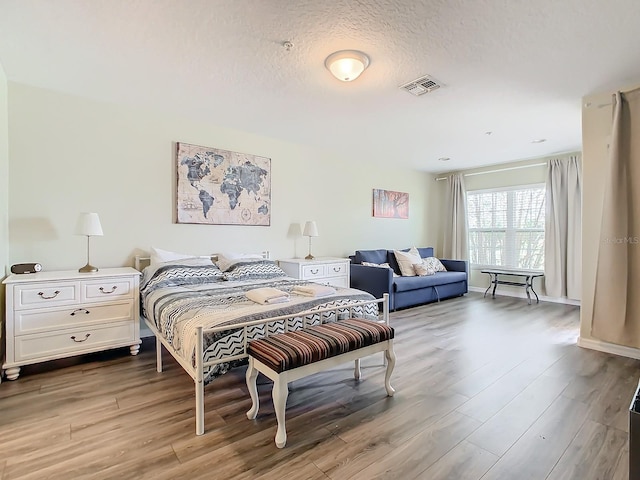 bedroom with hardwood / wood-style floors and a textured ceiling