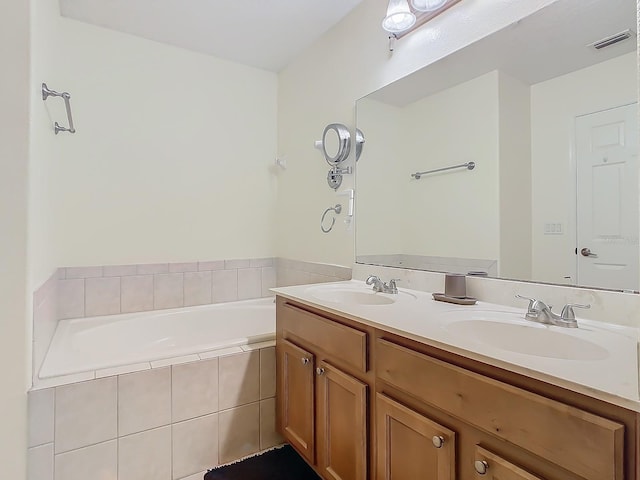 bathroom featuring vanity and tiled tub