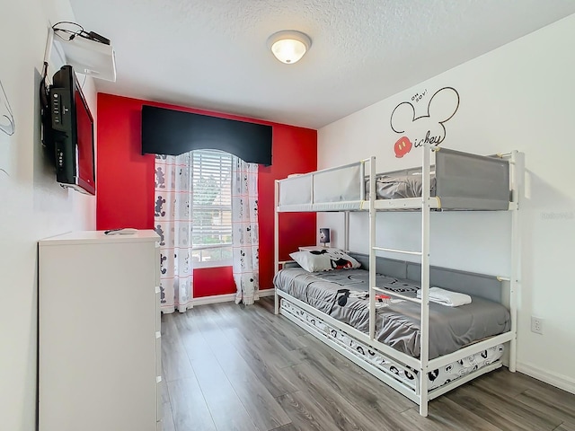 bedroom with a textured ceiling and wood-type flooring