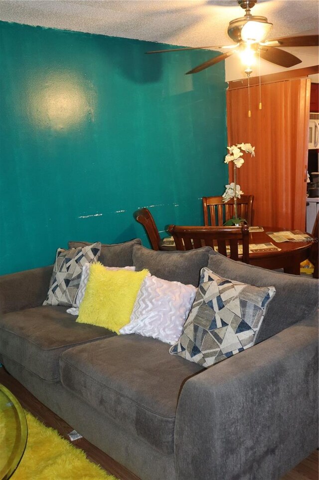 bedroom with ceiling fan, wood-type flooring, and a textured ceiling