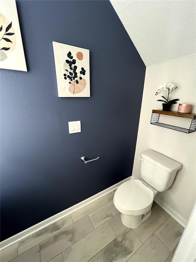 bathroom featuring toilet and vaulted ceiling