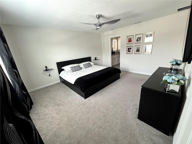 carpeted bedroom with connected bathroom, a textured ceiling, and ceiling fan