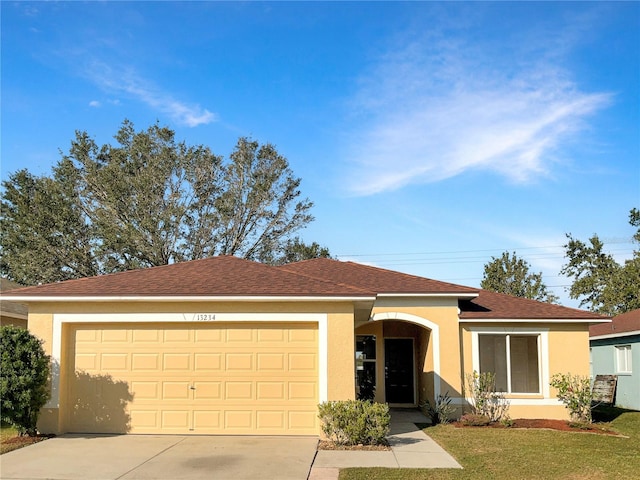 ranch-style home featuring a garage and a front lawn