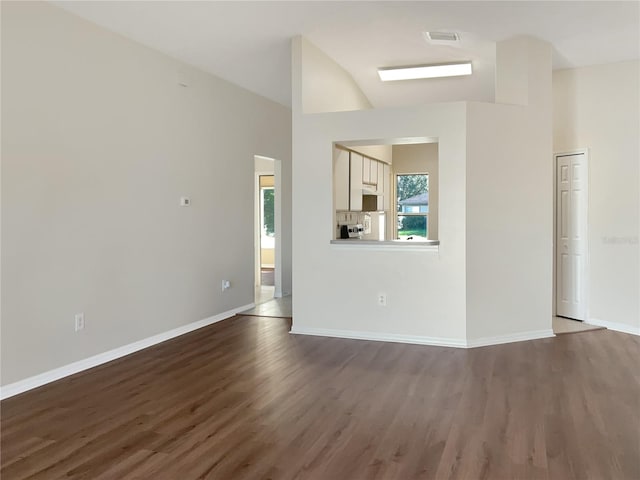 unfurnished living room with vaulted ceiling and dark hardwood / wood-style floors