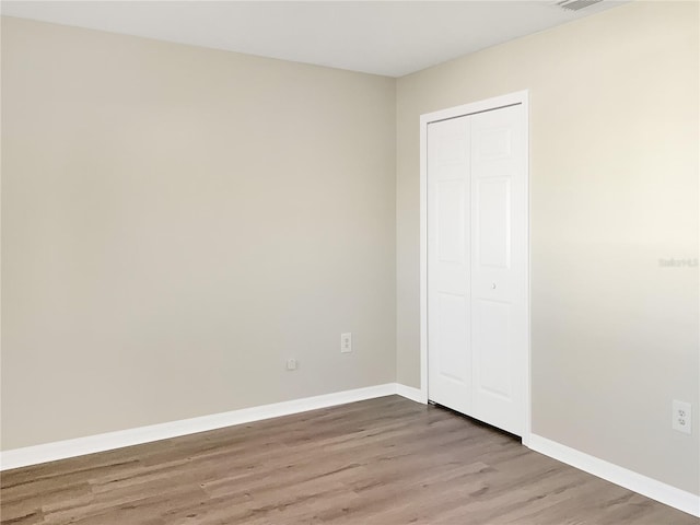 unfurnished bedroom with hardwood / wood-style flooring and a closet