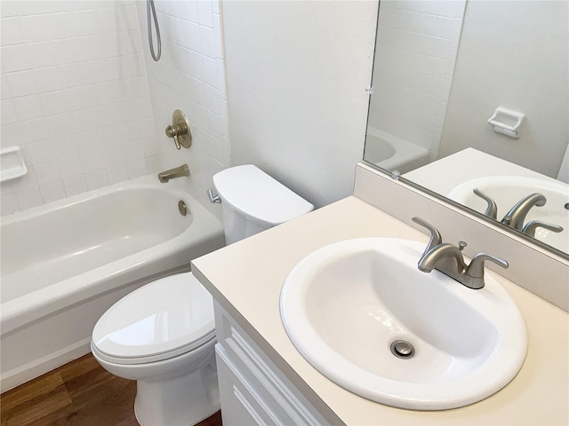 full bathroom with toilet, hardwood / wood-style floors, vanity, and shower / bathtub combination