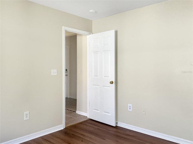 spare room with dark hardwood / wood-style flooring