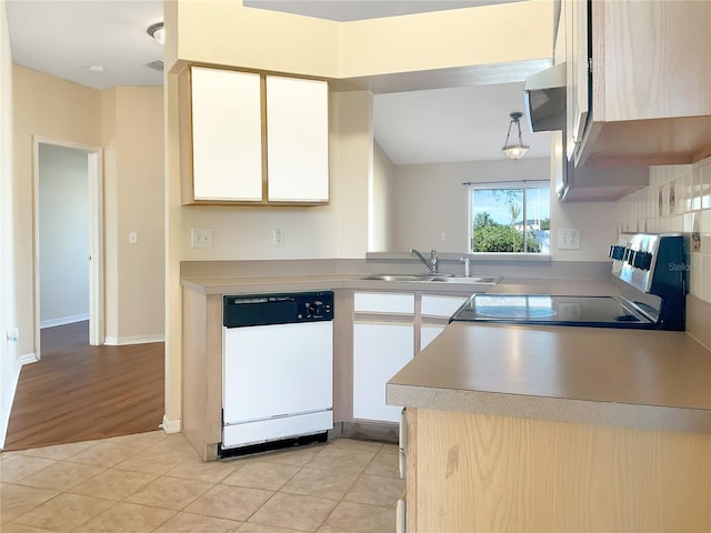 kitchen with stove, white dishwasher, vaulted ceiling, light tile patterned flooring, and sink