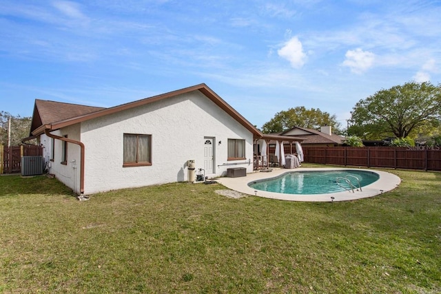 back of property with a fenced in pool, a patio area, and a yard