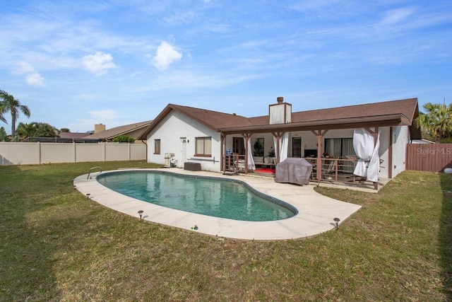 back of house with a patio, a fenced in pool, and a yard