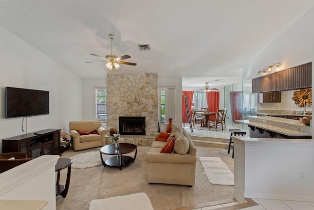 living room with ceiling fan, sink, a fireplace, and light tile patterned floors