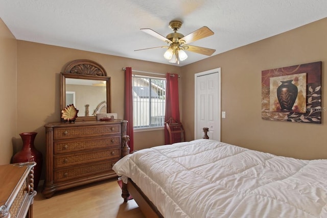 bedroom with light hardwood / wood-style flooring, a closet, and ceiling fan