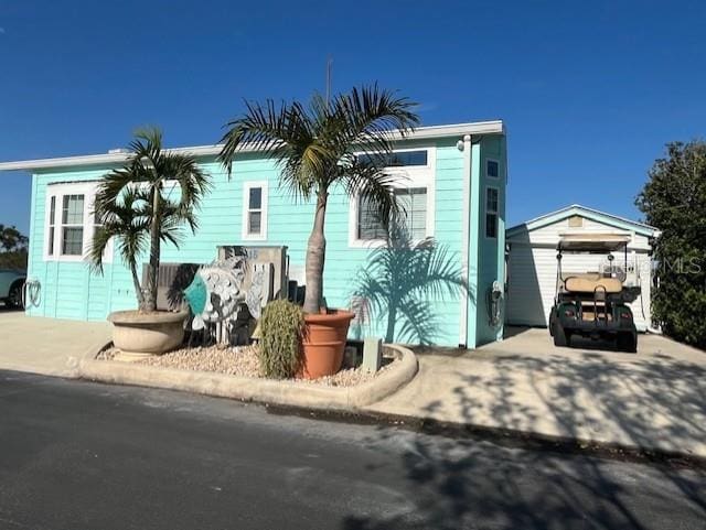 view of front of property featuring a storage shed