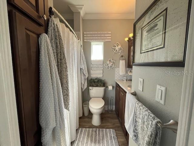 bathroom with wood-type flooring, toilet, ornamental molding, vanity, and a shower with curtain