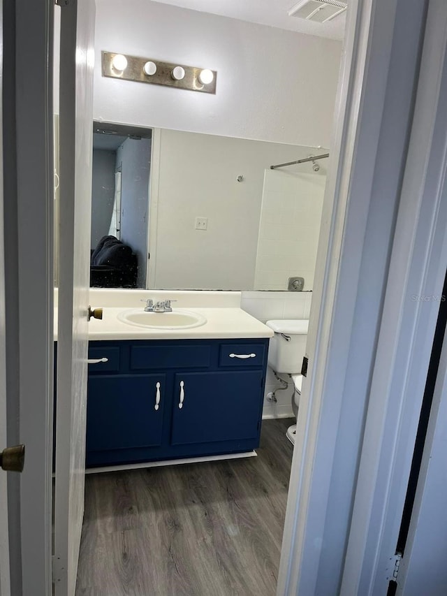 bathroom featuring hardwood / wood-style flooring, vanity, and toilet