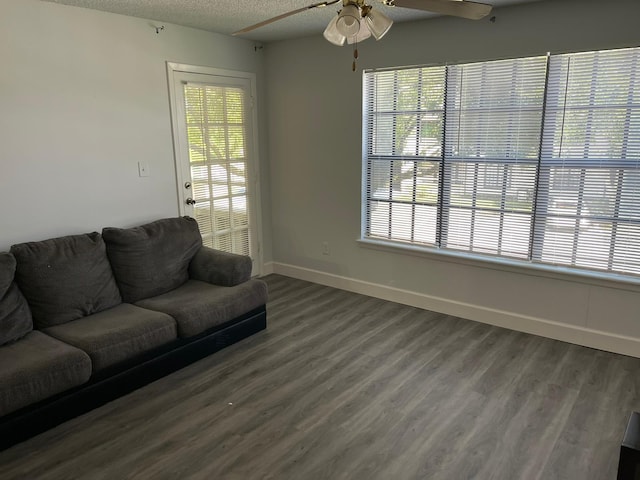 living room featuring ceiling fan, a wealth of natural light, wood-type flooring, and a textured ceiling