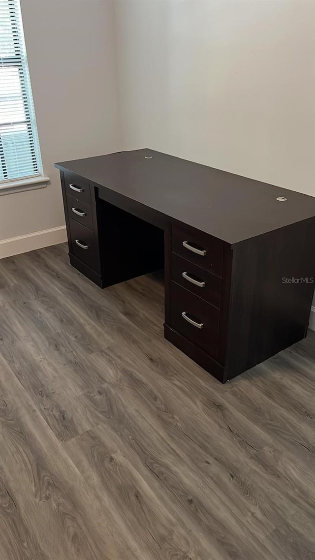 unfurnished office with hardwood / wood-style flooring and built in desk