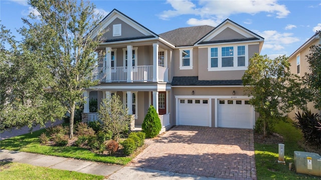 view of front of home with covered porch, a garage, and a balcony