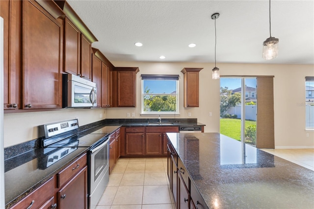 kitchen featuring light tile patterned floors, stainless steel appliances, sink, and pendant lighting