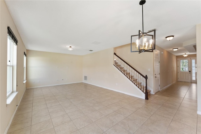 unfurnished living room featuring a notable chandelier and light tile patterned flooring