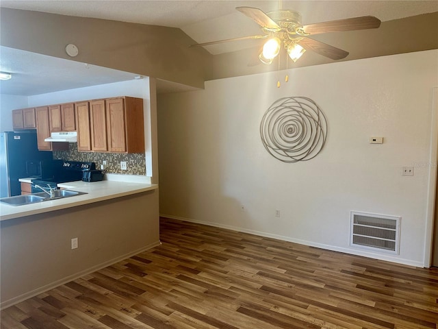 kitchen with dark hardwood / wood-style flooring, ceiling fan, backsplash, vaulted ceiling, and black electric range