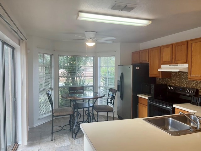 kitchen with sink, decorative backsplash, stainless steel appliances, and ceiling fan