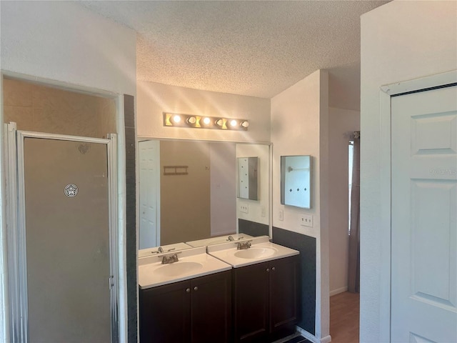 bathroom featuring vanity, a textured ceiling, wood-type flooring, and an enclosed shower