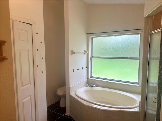 bathroom featuring tile patterned flooring, toilet, and separate shower and tub