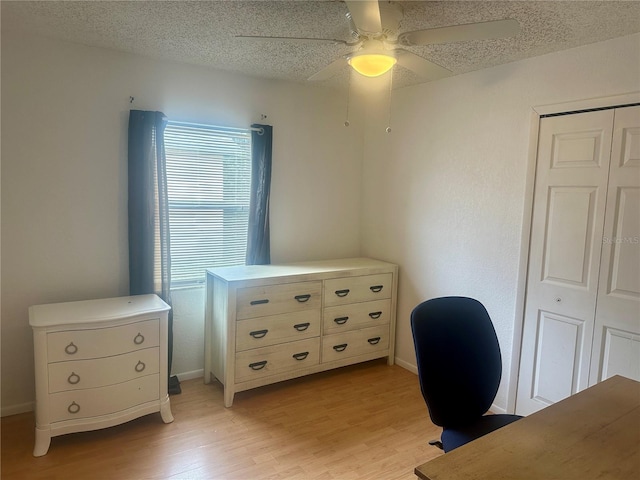 home office featuring light hardwood / wood-style flooring, a textured ceiling, and ceiling fan