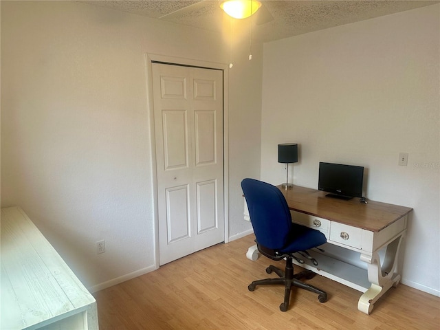 office with light hardwood / wood-style flooring and ceiling fan