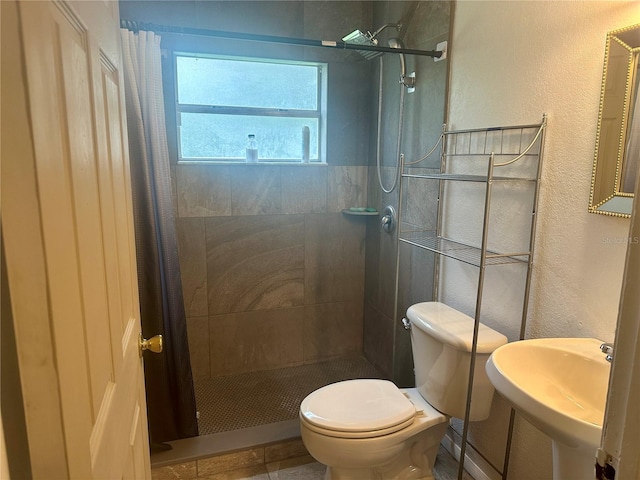 bathroom featuring sink, curtained shower, toilet, and tile patterned flooring