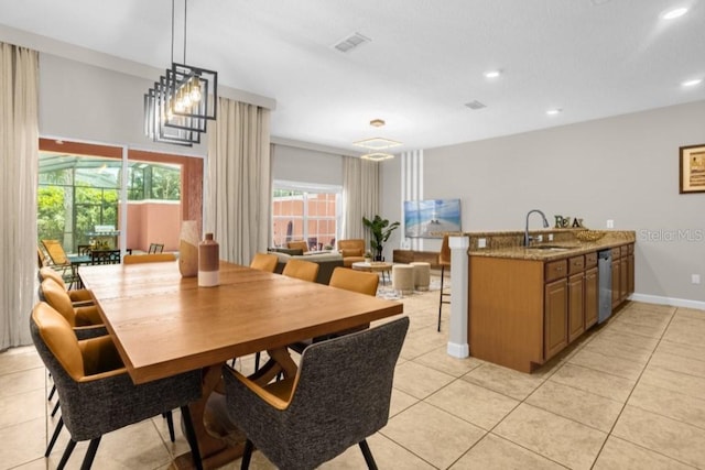 dining room with light tile patterned flooring, a notable chandelier, and sink