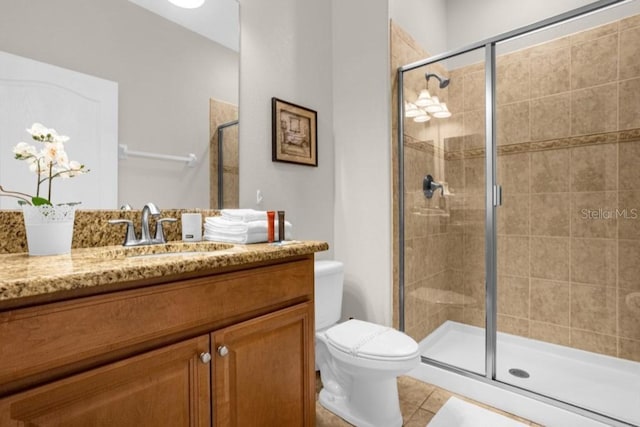 bathroom with toilet, an enclosed shower, vanity, and tile patterned floors