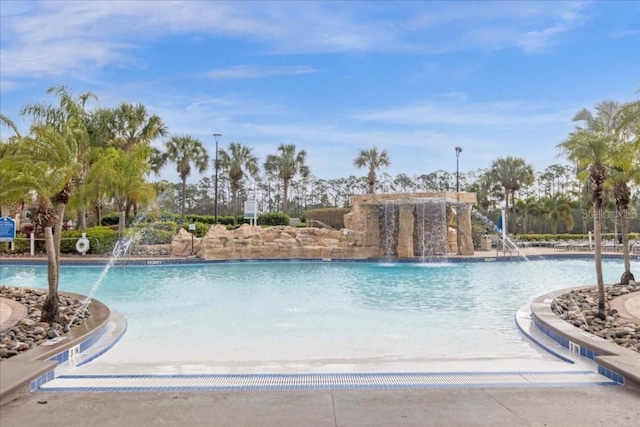 view of swimming pool with pool water feature