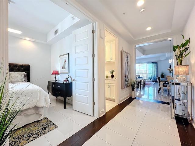 bedroom featuring connected bathroom and light hardwood / wood-style floors